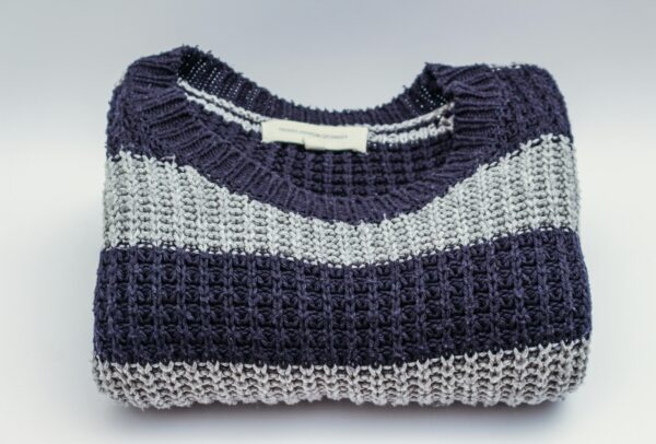 Warm knitted sweater with blue and white stripes, perfect for winter fashion.